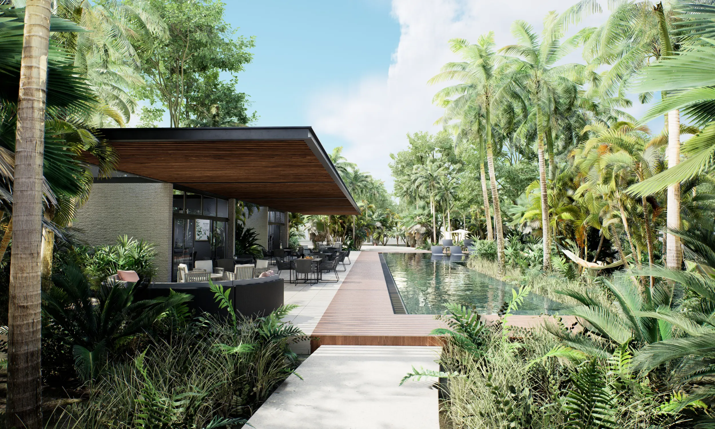 Outdoor patio beside a long pool surrounded by tropical plants at The Awen